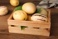 Fresh ripe pepino melons with green leaves in crate on wooden table