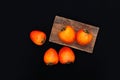 Fresh ripe persimmon on a black background . Persimmons fruit, Ripe sweet persimmons Royalty Free Stock Photo