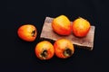 Fresh ripe persimmon on a black background . Persimmons fruit, Ripe sweet persimmons Royalty Free Stock Photo