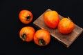 Fresh ripe persimmon on a black background . Persimmons fruit, Ripe sweet persimmons Royalty Free Stock Photo
