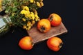 Fresh ripe persimmon on a black background . Persimmons fruit, Ripe sweet persimmons Royalty Free Stock Photo