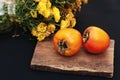 Fresh ripe persimmon on a black background . Persimmons fruit, Ripe sweet persimmons Royalty Free Stock Photo