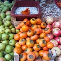 Fresh ripe  persimmons placed on table in market. Organic persimmon fruit in pile at local farmers market Royalty Free Stock Photo