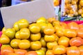 Fresh ripe persimmons placed on table in market for sale with em Royalty Free Stock Photo