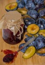 Fresh ripe plum - raw materials for making homemade jam and a glass jar with jam Royalty Free Stock Photo