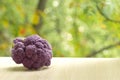 Fresh ripe purple cauliflower. Healthy food on table on defocus autumn background.