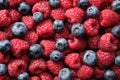 Fresh ripe raspberries and blueberries, top view, flat lay. Beautiful background of summer berries Royalty Free Stock Photo