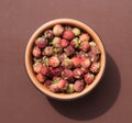 Fresh ripe red berries of wild forest strawberries in brown bowl. Top view. Meadow strawberry on brown background Royalty Free Stock Photo