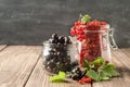 Fresh ripe red black currant berry in various glass jars on a dark background. Horizontal frame. Selective focus. Royalty Free Stock Photo