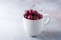 Fresh ripe red cherries in a white mug on a gray stone background Closeup Water drops Royalty Free Stock Photo