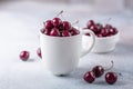 Fresh ripe red cherries in a white mug on a gray stone background Closeup Water drops Royalty Free Stock Photo