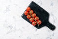 Fresh ripe red cherry tomatoes on a marble cutting board, top view with copy space Royalty Free Stock Photo