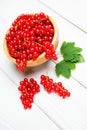 Fresh ripe red currant berries Ribes rubrum with leaves in bowl on white wooden table. Royalty Free Stock Photo