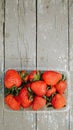 Fresh ripe red organic berry strawberries in a plastic box. Closeup view on a natural texture background. Royalty Free Stock Photo