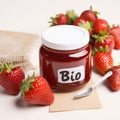 Fresh ripe red strawberries and strawberry jam in a jar, word BIO. Royalty Free Stock Photo