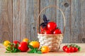 Fresh ripe red and yellow tomatoes in a wicker basket on a wooden table Royalty Free Stock Photo