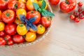 Fresh ripe red and yellow tomatoes in a wicker basket on a wooden table. Top view Royalty Free Stock Photo