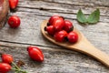 Fresh ripe rosehips on wooden background