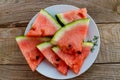 Fresh ripe sliced watermelon in white plate on rustic wooden table Royalty Free Stock Photo