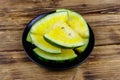 Fresh ripe sliced yellow watermelon in a plate on wooden table Royalty Free Stock Photo