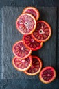Fresh ripe slices of blood oranges on a black slate background. Royalty Free Stock Photo