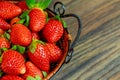 Fresh ripe strawberries in a basket on wooden background Royalty Free Stock Photo