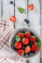 Fresh ripe strawberries and blueberries in a bowl on white wooden rustic background Royalty Free Stock Photo