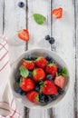 Fresh ripe strawberries and blueberries in a bowl on white wooden rustic background Royalty Free Stock Photo