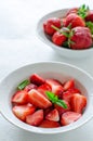 Fresh ripe strawberries in bowl on white background, vertical