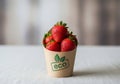 Fresh ripe strawberries in eco-friendly brown paper container on white background Royalty Free Stock Photo
