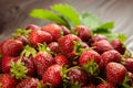 Fresh ripe strawberries with green leaves on blurred wooden background, closeup. Red berries Royalty Free Stock Photo