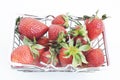 Fresh ripe strawberries in a tiny supermarket trolley , still life