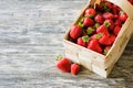 Fresh ripe strawberries in a wooden basket on a wooden background. Organic juicy berries Royalty Free Stock Photo