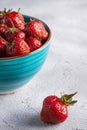 Fresh ripe strawberry fruits in blue bowl, summer vitamin berries on grey stone background Royalty Free Stock Photo