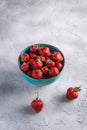 Fresh ripe strawberry fruits in blue bowl, summer vitamin berries on grey stone background Royalty Free Stock Photo