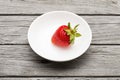 Fresh ripe strawberry in a simple white bowl