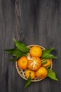 Fresh ripe tangerines with leaves in basket. New Year or Christmas wooden background. Festive good mood concept Royalty Free Stock Photo