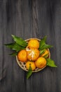 Fresh ripe tangerines with leaves in basket. New Year or Christmas wooden background. Festive good mood concept Royalty Free Stock Photo