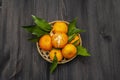 Fresh ripe tangerines with leaves in basket. New Year or Christmas wooden background. Festive good mood concept Royalty Free Stock Photo