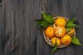 Fresh ripe tangerines with leaves in basket. New Year or Christmas wooden background. Festive good mood concept Royalty Free Stock Photo