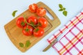 Fresh and ripe tomatoes, basil and knife on cutting board Royalty Free Stock Photo