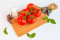 Fresh and ripe tomatoes, basil and salt on cutting board Royalty Free Stock Photo