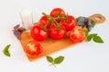 Fresh and ripe tomatoes, basil and salt on cutting board Royalty Free Stock Photo