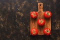 Fresh ripe tomatoes on a cutting board, dark background, top view. A copy of the space, flat lay. Royalty Free Stock Photo