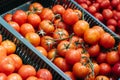 Fresh ripe tomatoes in a plastic box at the food store. Vegetarian food