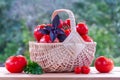 Fresh ripe tomatoes in a wicker basket on a wooden table Royalty Free Stock Photo