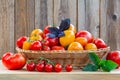 Fresh ripe tomatoes in a wicker basket on a wooden table Royalty Free Stock Photo