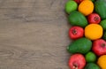 Fresh ripe tropical fruits on wooden table. Avocados, oranges, limes and pomegranates.Assorted exotic fruits.