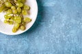 Fresh ripe white grape berries in wooden bowl on blue textured background Royalty Free Stock Photo