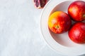 Fresh ripe whole and slices of blood oranges in a plate on a white stone background. Copy space and close up. Royalty Free Stock Photo